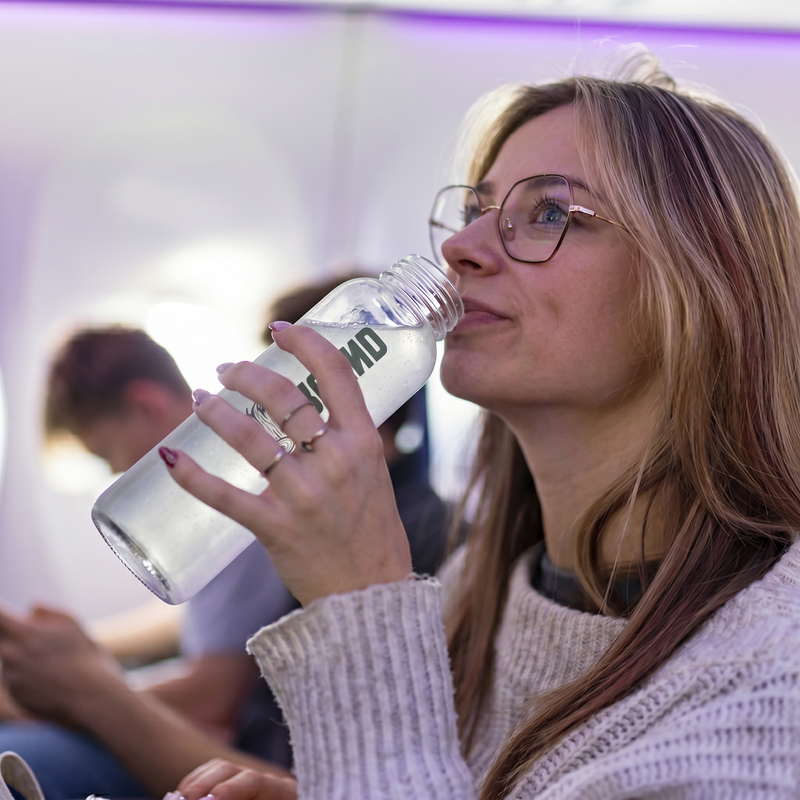 girl drinking ground electrolytes on plane