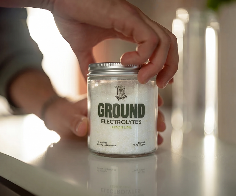 hand opening a jar of ground electrolytes