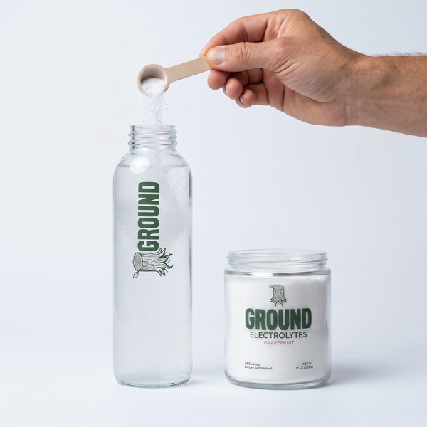 pouring ground electrolytes into glass bottle with included wood scoop