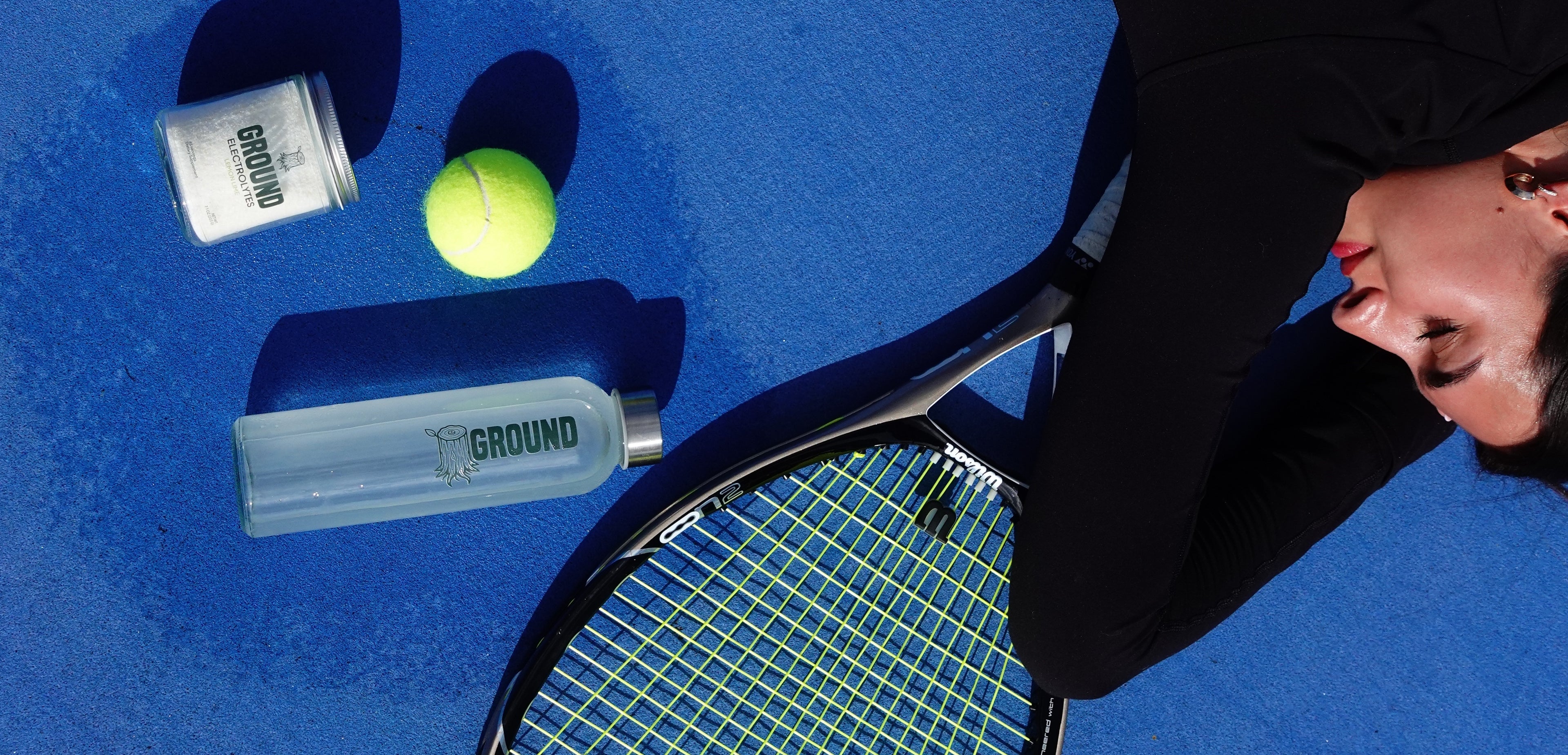 tennis girl lying on tennis court with ground electrolytes